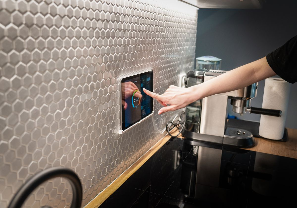 Panel táctil de domótica en la pared de una cocina moderna